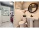 Charming bathroom with pedestal sink, wainscoting, and laundry area with washer and dryer at 6646 S Fundy Ct, Centennial, CO 80016