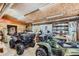 Spacious garage featuring two ATVs, a workbench, and ample storage for tools and equipment at 6646 S Fundy Ct, Centennial, CO 80016