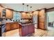 Spacious kitchen featuring wood cabinets, center island, black countertops, and stainless steel refrigerator at 6646 S Fundy Ct, Centennial, CO 80016