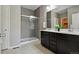 Elegant bathroom with a dual sink vanity, gray tile shower, and modern fixtures at 806 Peony Ct, Brighton, CO 80601