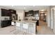 Open kitchen with dark cabinets, granite countertops, stainless steel appliances, and island seating at 806 Peony Ct, Brighton, CO 80601