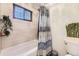 Bright bathroom features a tub with shower, neutral tiling, and stylish decor at 32 Eagle Dr, Littleton, CO 80123