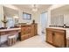 Bright bathroom featuring wood cabinets, granite counters, a vanity area, and tile flooring at 32 Eagle Dr, Littleton, CO 80123