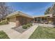 Charming brick home featuring a spacious front patio, lush lawn, and attached two-car garage at 32 Eagle Dr, Littleton, CO 80123