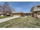 Charming brick home showcasing a well-manicured lawn and attached two-car garage at 32 Eagle Dr, Littleton, CO 80123