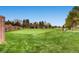 Scenic view of a lush, well-manicured golf course with mature trees and a clear blue sky at 32 Eagle Dr, Littleton, CO 80123