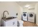 Convenient laundry room with modern washer and dryer, plus a sink for easy cleanup at 32 Eagle Dr, Littleton, CO 80123