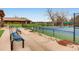 Community tennis courts with spectator seating and partial views of the clubhouse at 32 Eagle Dr, Littleton, CO 80123