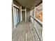 A balcony with wood decking and white railing; a sliding glass door provides access to the interior at 18193 E Kentucky Ave # 201, Aurora, CO 80017