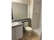 Bright bathroom with a vanity, toilet, and shower with white tiling and simple fixtures at 18193 E Kentucky Ave # 201, Aurora, CO 80017