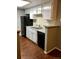 Kitchen featuring white cabinets, stainless steel sink, and a black dishwasher against wood floors at 18193 E Kentucky Ave # 201, Aurora, CO 80017