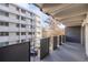Balcony of the condo with black railing and view of the adjacent building and parking at 1265 Race St # 208, Denver, CO 80206
