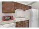 Bright kitchen features wood cabinets, white appliances, and neutral countertops at 1265 Race St # 208, Denver, CO 80206