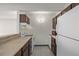 Efficient kitchen features wood cabinets, white appliances, and laminate countertops at 1265 Race St # 208, Denver, CO 80206