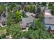 Aerial view of home with deck nestled amongst mature trees in a residential neighborhood at 292 Summerwood Ln, Castle Pines, CO 80108