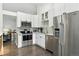 Well-lit kitchen features stainless steel appliances, white cabinets, and a subway tile backsplash at 292 Summerwood Ln, Castle Pines, CO 80108