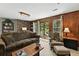 Cozy living room with wood-paneled walls, brick accent, and sliding door to outdoor area at 292 Summerwood Ln, Castle Pines, CO 80108