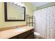 Bathroom with a granite-topped vanity and a colorful polka dot shower curtain at 4786 S Yampa St, Aurora, CO 80015
