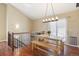 Open dining area with wooden flooring, a table, a bench, and a modern chandelier at 4786 S Yampa St, Aurora, CO 80015