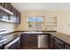 Kitchen featuring sleek black countertops, stainless steel appliances, and ample cabinet space at 4786 S Yampa St, Aurora, CO 80015