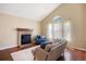 Bright living room with a brick fireplace, plush sofa, and large windows with natural light at 4786 S Yampa St, Aurora, CO 80015