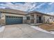 Tan and green two-car garage home with stone accents and covered entry at 804 W 128Th Pl, Westminster, CO 80234