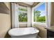 Soaking tub beneath bright windows offers a tranquil retreat with views of the surrounding landscape at 188 S Rogers Way, Golden, CO 80401
