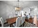Spacious dining room featuring a dark wood table, white chairs, modern chandelier, and hardwood floors at 188 S Rogers Way, Golden, CO 80401
