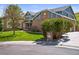Well-maintained front yard with lush lawn and mature landscaping and brick accents on the exterior at 188 S Rogers Way, Golden, CO 80401
