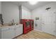 Laundry room with red washer and dryer, white cabinets, a utility sink, and light wood-look flooring at 188 S Rogers Way, Golden, CO 80401
