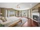 Spacious primary bedroom featuring hardwood floors, a cozy fireplace, and bright natural light from the surrounding windows at 188 S Rogers Way, Golden, CO 80401