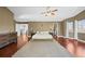 Well-lit primary bedroom with hardwood floors, a ceiling fan, walk-in closet, and an ensuite bathroom at 188 S Rogers Way, Golden, CO 80401