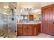 Bathroom with wood cabinets, granite counters, large mirror, and glass enclosed shower at 6928 S Eaton St, Littleton, CO 80128