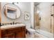 Bathroom featuring a round mirror, tile shower and updated fixtures at 6928 S Eaton St, Littleton, CO 80128