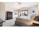 Bright bedroom featuring large windows with views, a dresser and neutral colored carpet at 6928 S Eaton St, Littleton, CO 80128