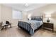 Cozy bedroom with a black iron bed frame, soft blue bedding, and a warm, inviting atmosphere at 6928 S Eaton St, Littleton, CO 80128