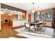 Charming dining area with hardwood floors, modern light fixtures, and an open view into the kitchen at 6928 S Eaton St, Littleton, CO 80128