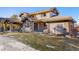 Beautiful tan stucco and stone home exterior featuring covered patio and well maintained lawn at 6928 S Eaton St, Littleton, CO 80128