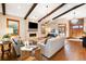 Elegant living room featuring wood flooring, exposed beams, a stone fireplace, and lots of natural light at 6928 S Eaton St, Littleton, CO 80128