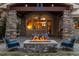 Covered outdoor patio with a stone fireplace and comfortable seating, ideal for relaxation and entertaining at 6928 S Eaton St, Littleton, CO 80128