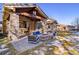 Inviting outdoor living area with a stone fireplace and comfortable seating, perfect for enjoying the outdoors at 6928 S Eaton St, Littleton, CO 80128