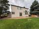 Spacious backyard with mature trees and a sliding glass door entrance at 10027 Sylvestor Rd, Highlands Ranch, CO 80129