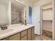 Bathroom featuring double sinks, a large mirror, and a shower with handicap supports at 12265 E 2Nd Dr, Aurora, CO 80011