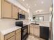 Well-lit kitchen featuring sleek, black appliances and view to the living room at 12265 E 2Nd Dr, Aurora, CO 80011