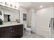 Bathroom with tub, shower, and dark brown vanity at 155 S Monaco Pkwy # 114, Denver, CO 80224