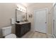 Modern bathroom with dark vanity, large mirror, and tile flooring at 155 S Monaco Pkwy # 114, Denver, CO 80224