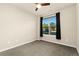 Simple bedroom with large window and carpeted floor at 155 S Monaco Pkwy # 114, Denver, CO 80224