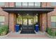 Modern building entrance with brick exterior, double doors, and attractive landscaping at 155 S Monaco Pkwy # 114, Denver, CO 80224