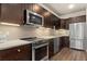 Modern kitchen with stainless steel appliances and dark wood cabinets at 155 S Monaco Pkwy # 114, Denver, CO 80224