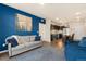 Open living room, kitchen, and dining area with blue accent wall at 155 S Monaco Pkwy # 114, Denver, CO 80224